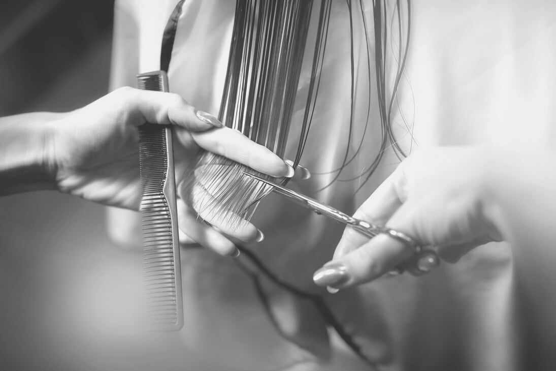 Hairdresser doing haircut in hairdressing salon.